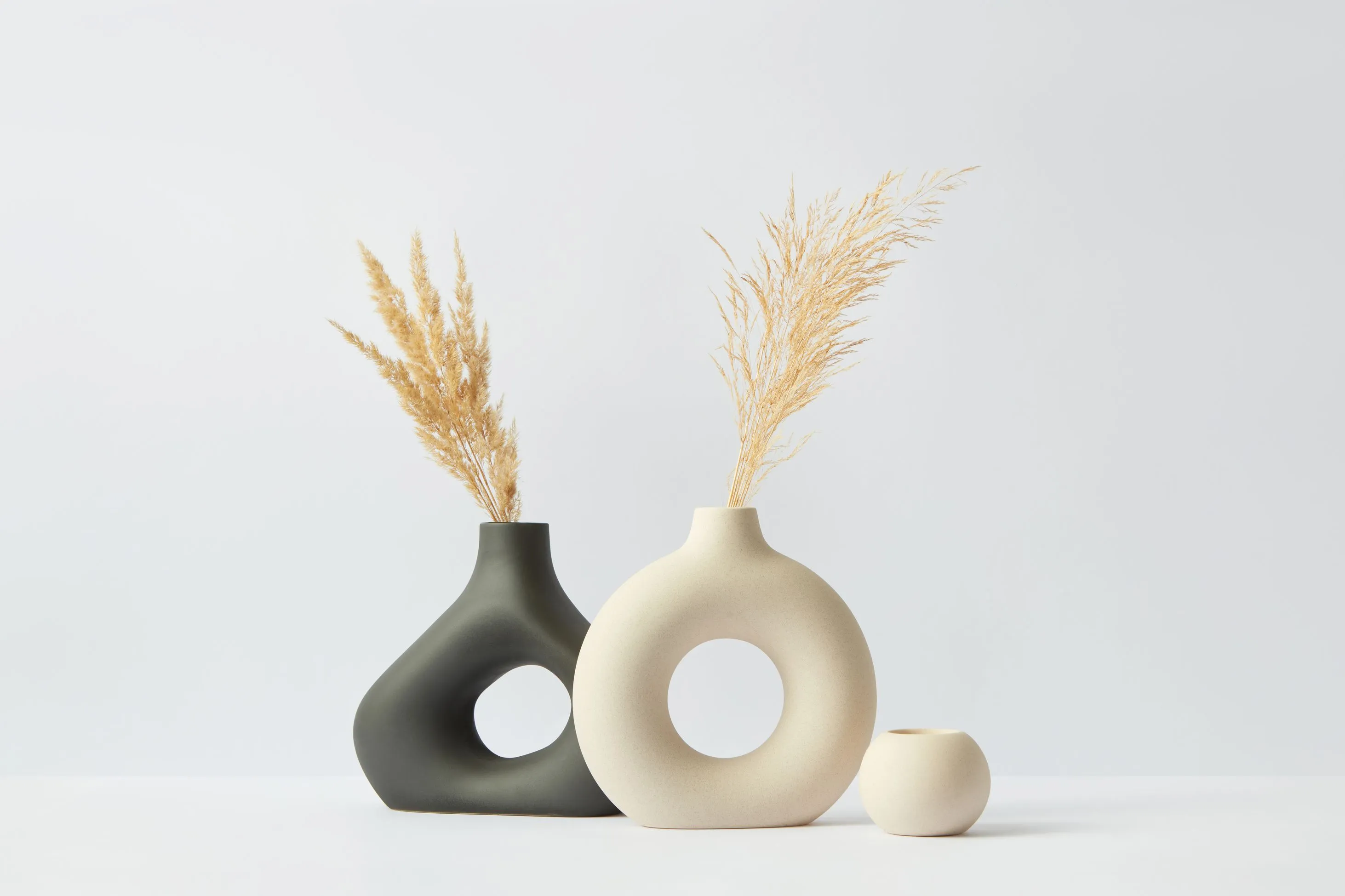 Two vases with a smaller vase next to them