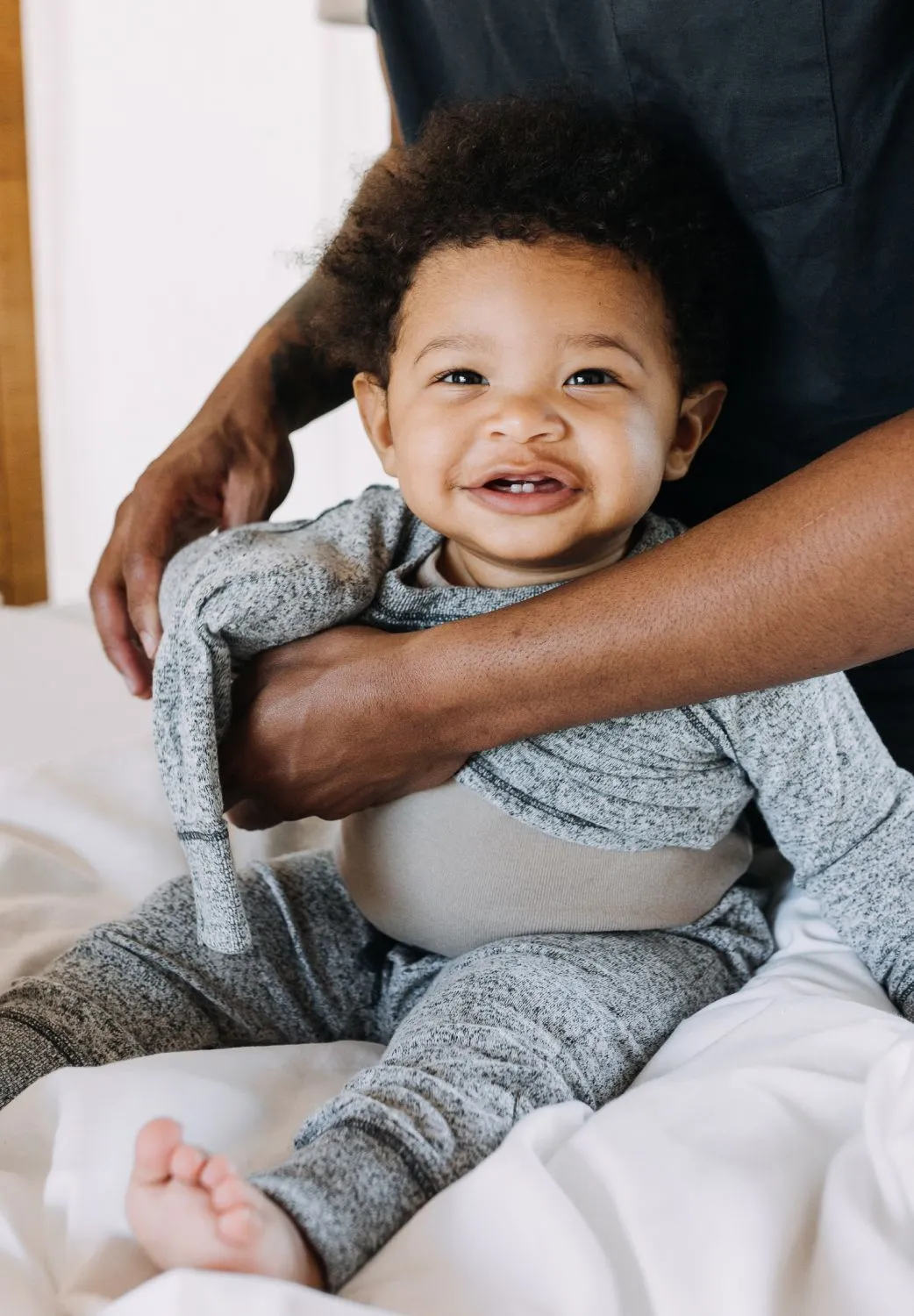 Toddler smiles in fathers embrace
