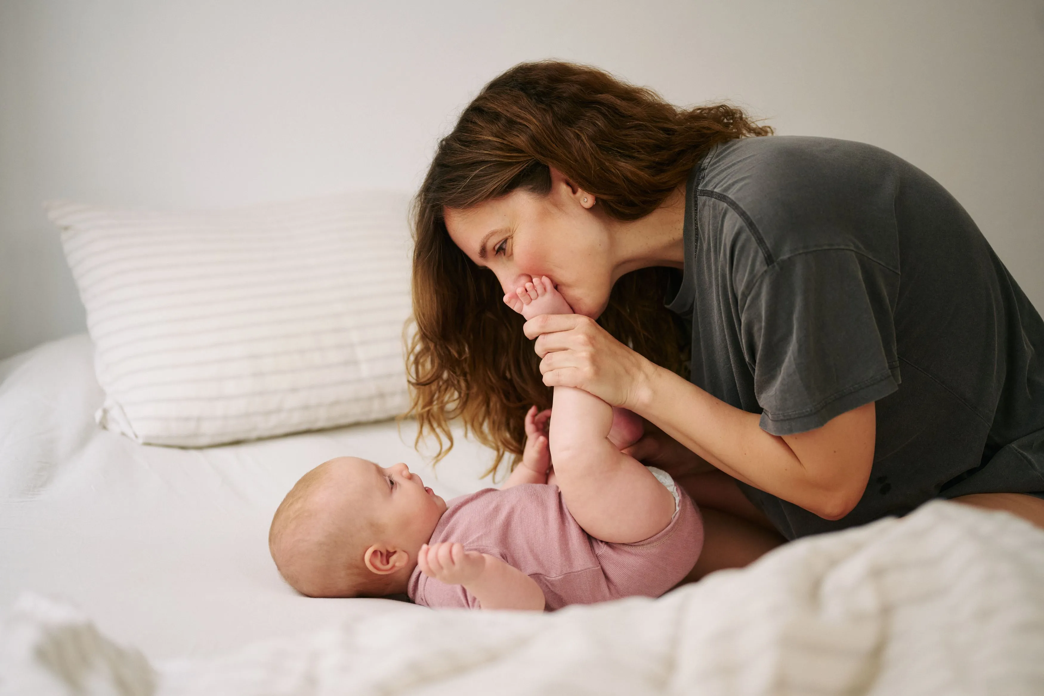 Mother kissing newborn baby's feet