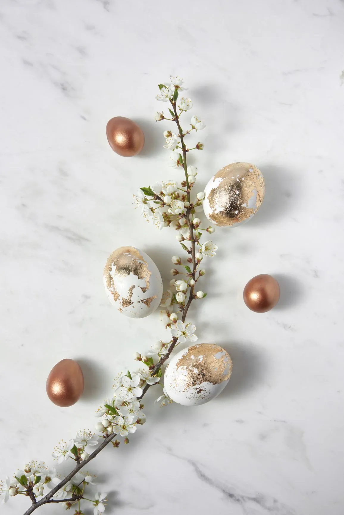 A beautiful display of eggs on a marble surface, accented by fresh flowers.